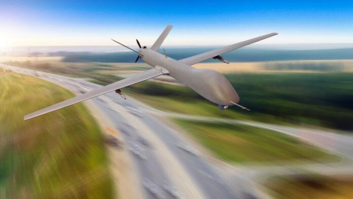 Unmanned military aircraft flies at high speed over the highway and city